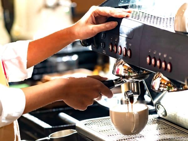 Barista prepara il caffè con la macchina rispettando l' HACCP bar